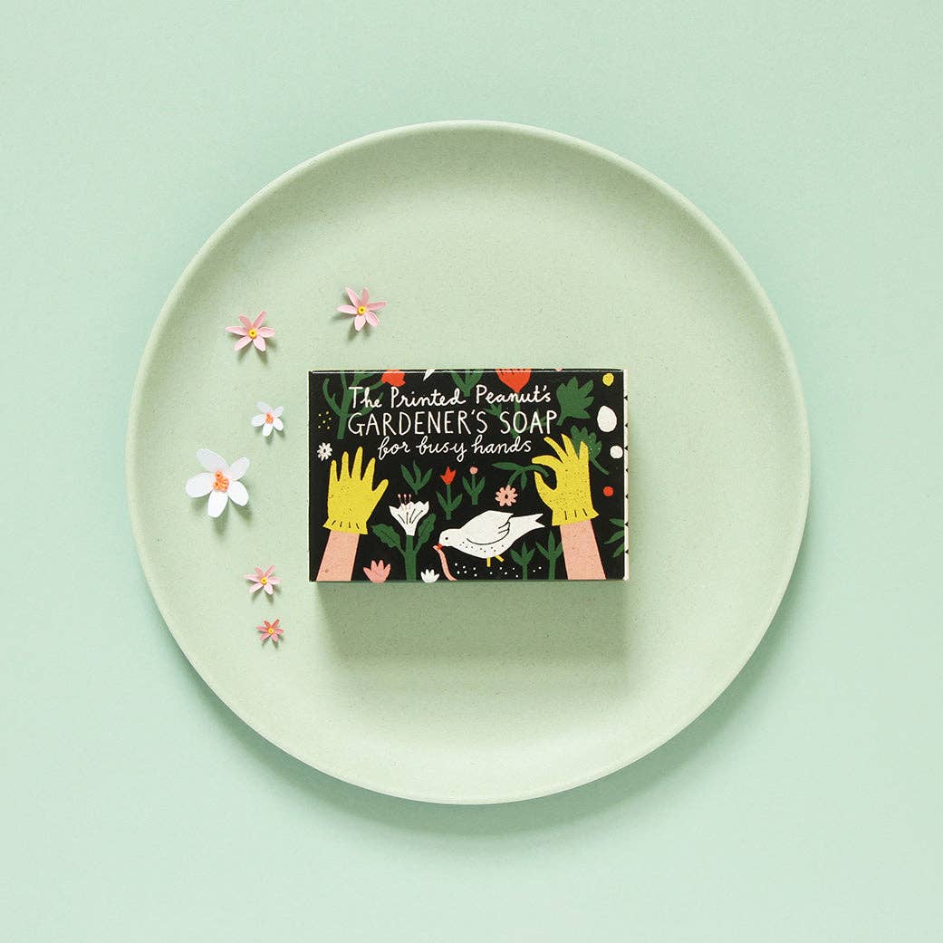 Box of 'The Printed Pantry's Gardener's Soap' on a white plate with flowers against a light green background