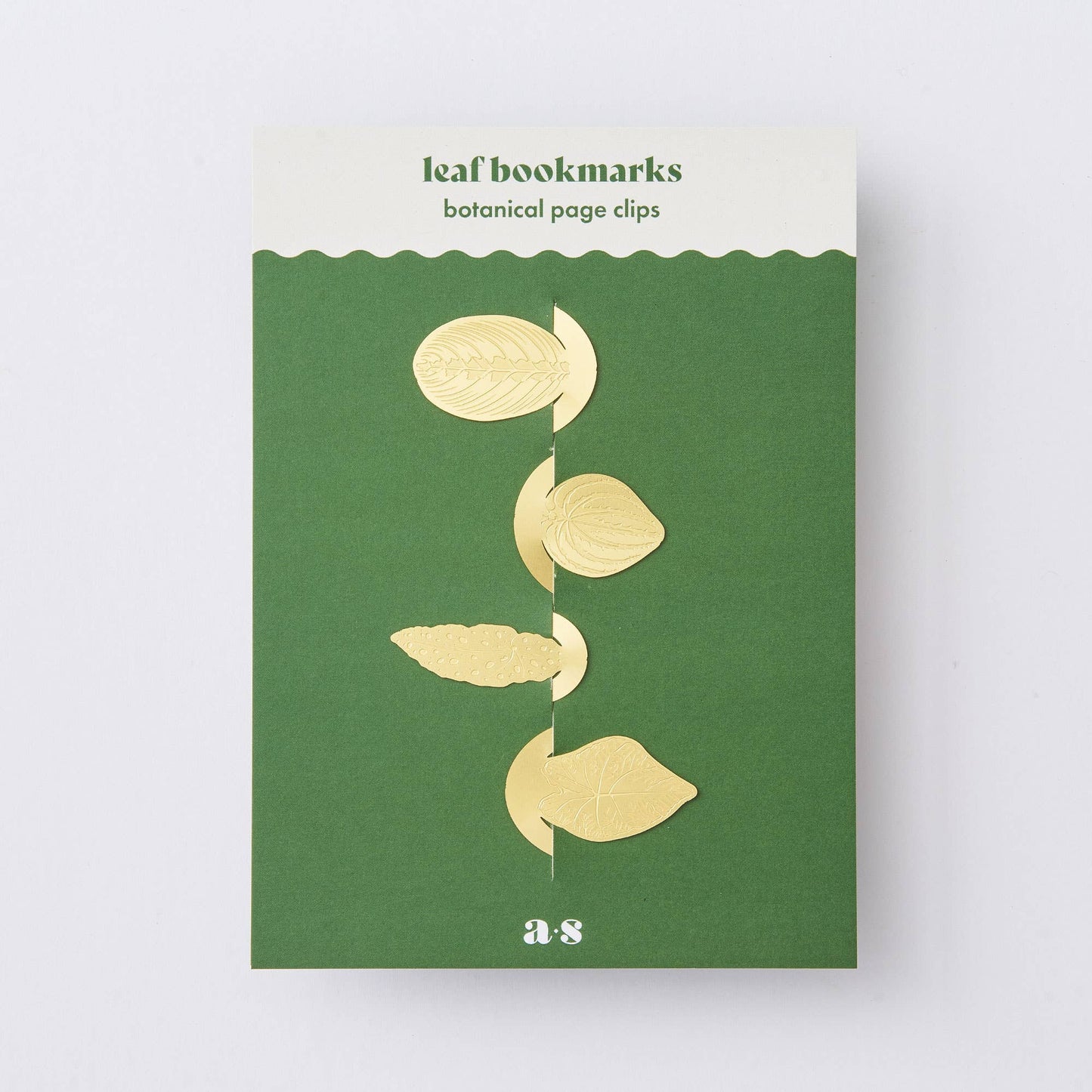 Packaging of leaf bookmarks with gold leaf designs on a green background