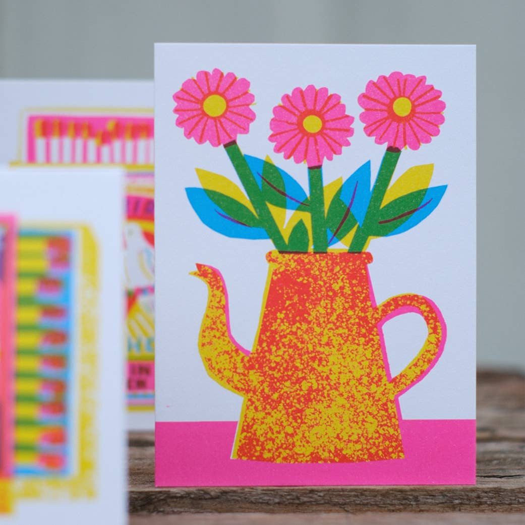 Colorful card with a watering can and flowers design on a white background
