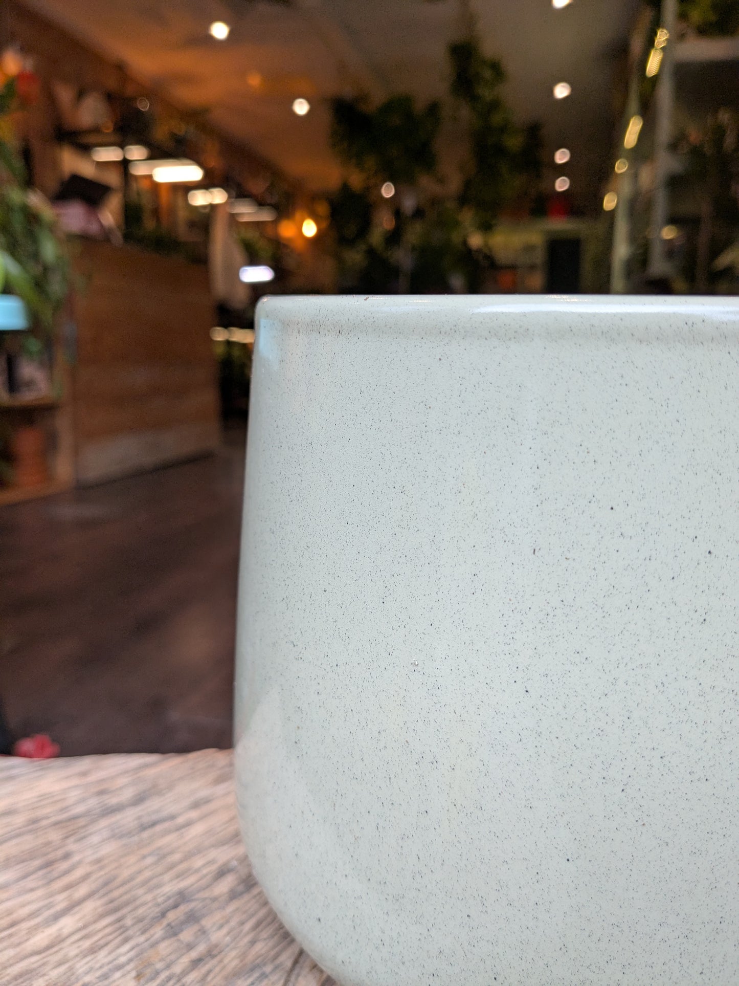 Close-up of a textured white ceramic cup with a blurred indoor background