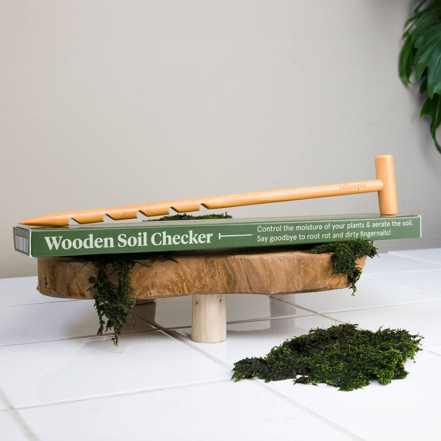 Wooden soil checker with green label on a white surface