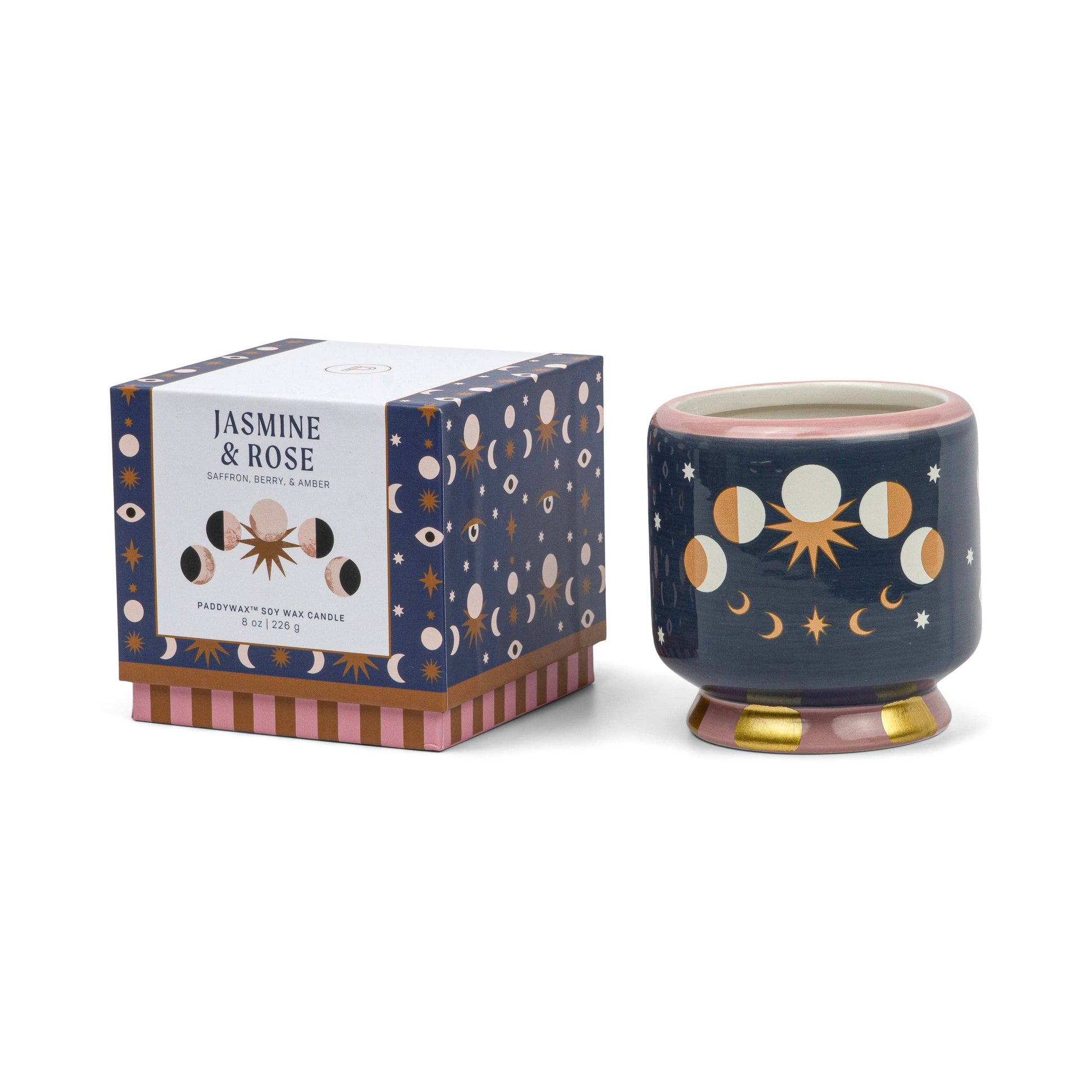 Decorative candle with moon phases design next to its packaging on a white background
