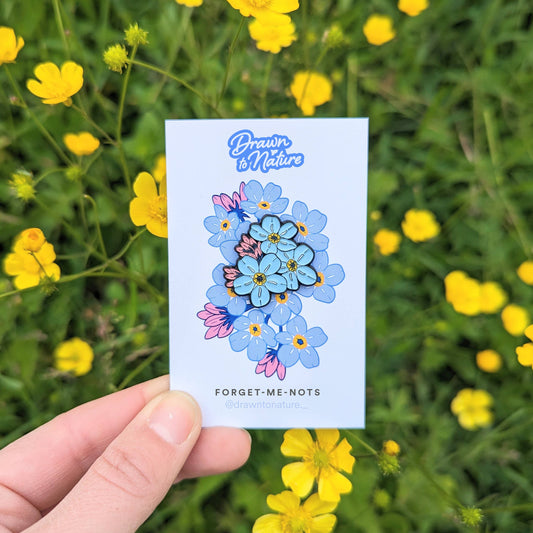 Card with floral design held in front of a field of yellow flowers