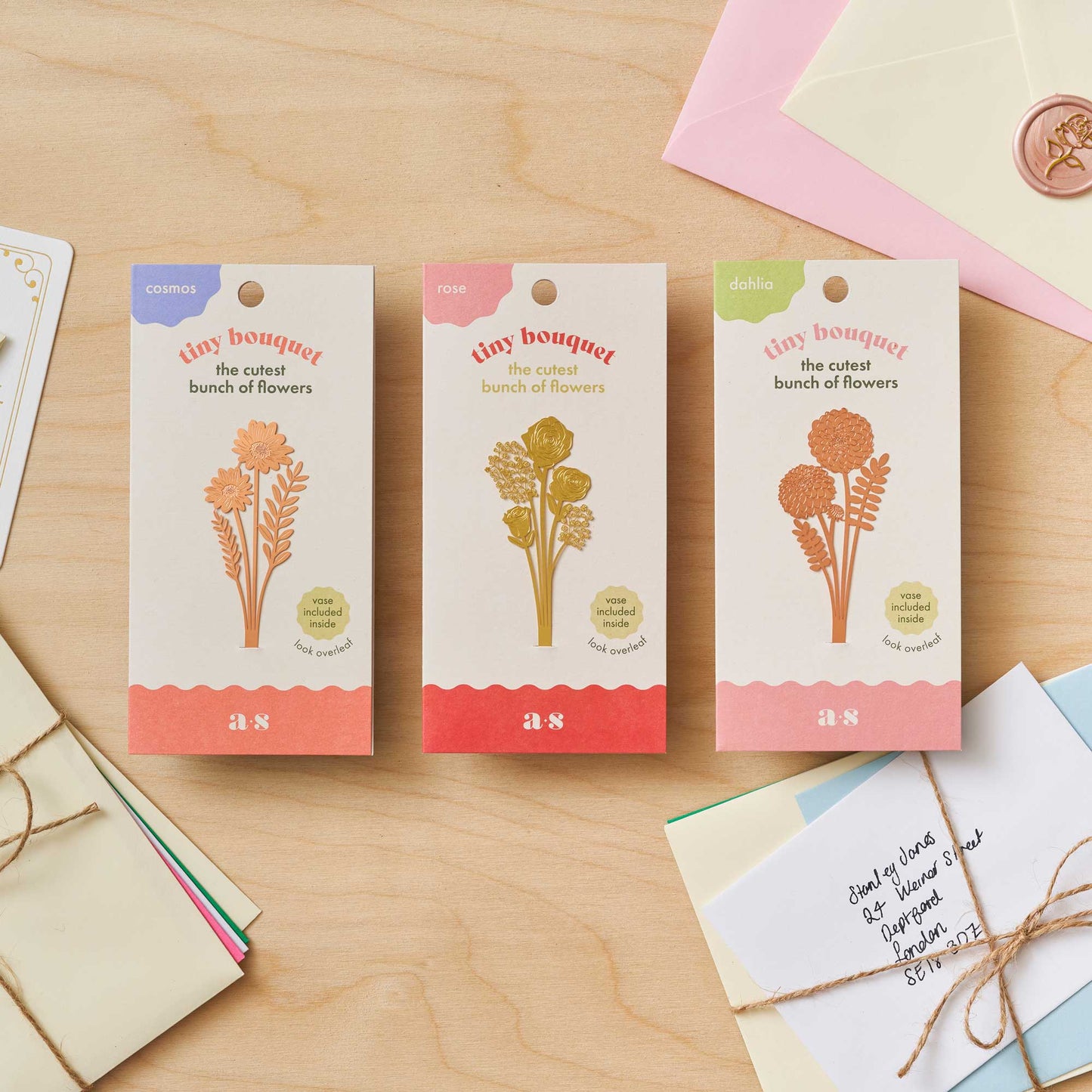 Three packages of 'Boy bouquet' on a wooden surface with stationery items.