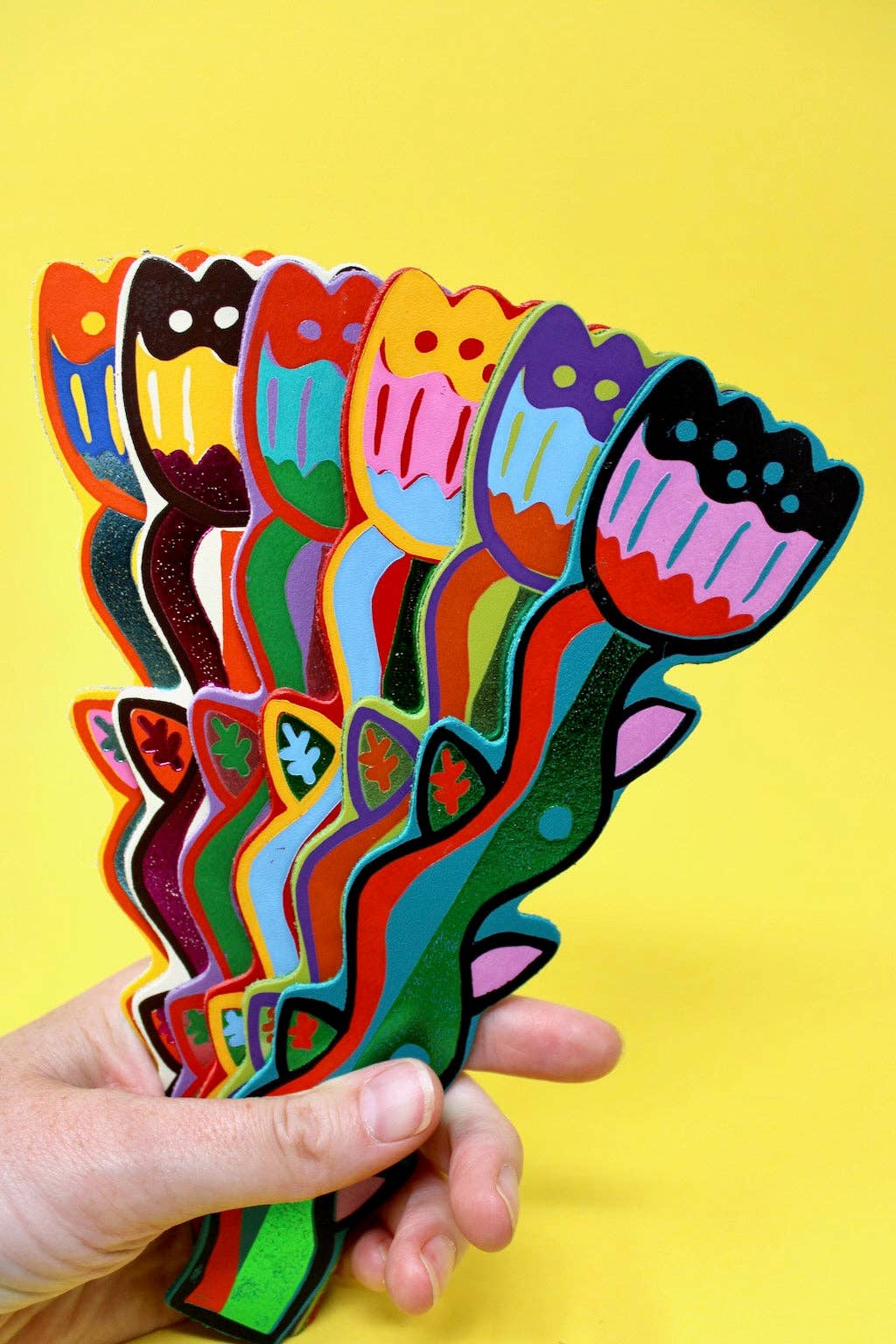 Colorful tulip-shaped cutouts held against a yellow background