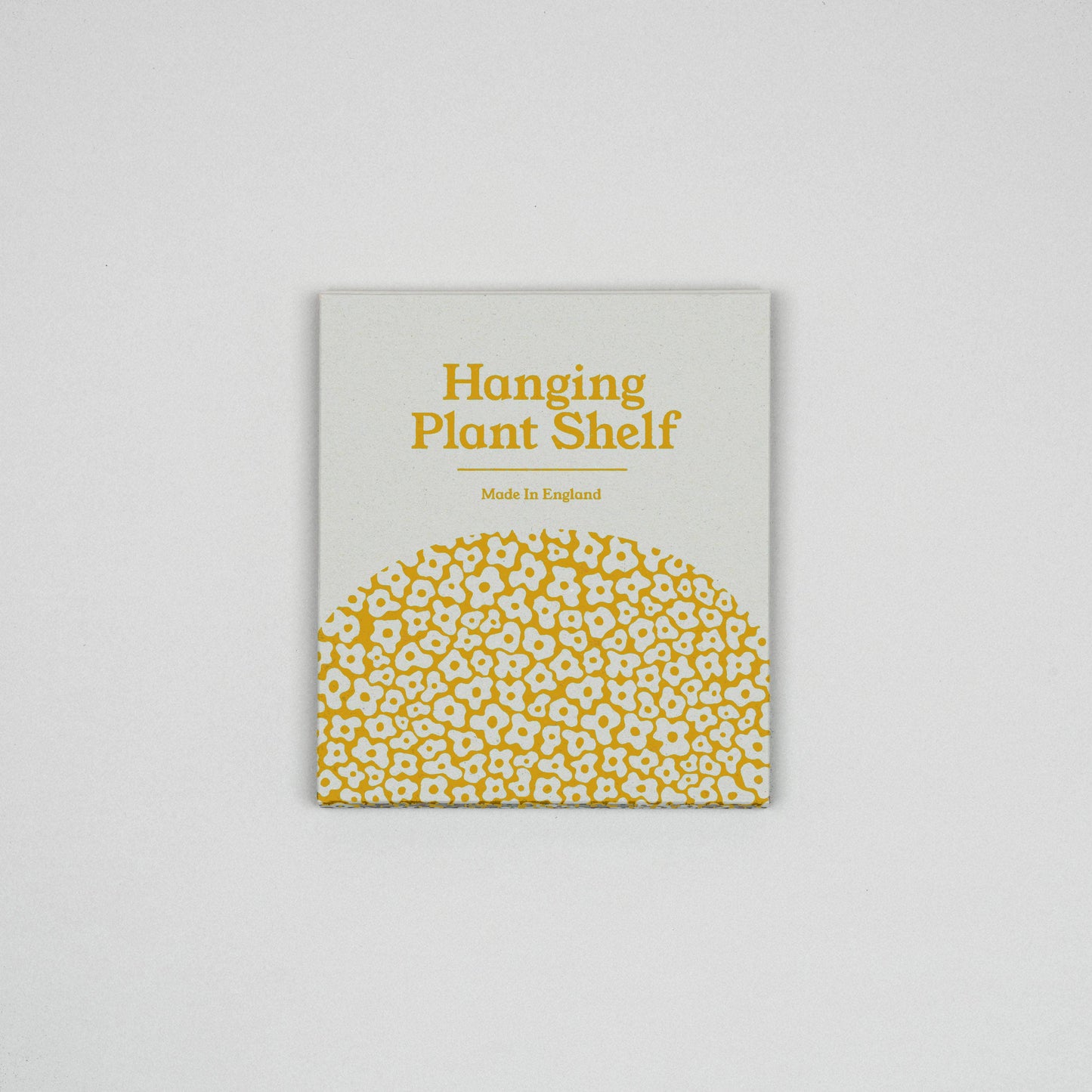 Product packaging for a hanging plant shelf with yellow text and pattern on a gray background