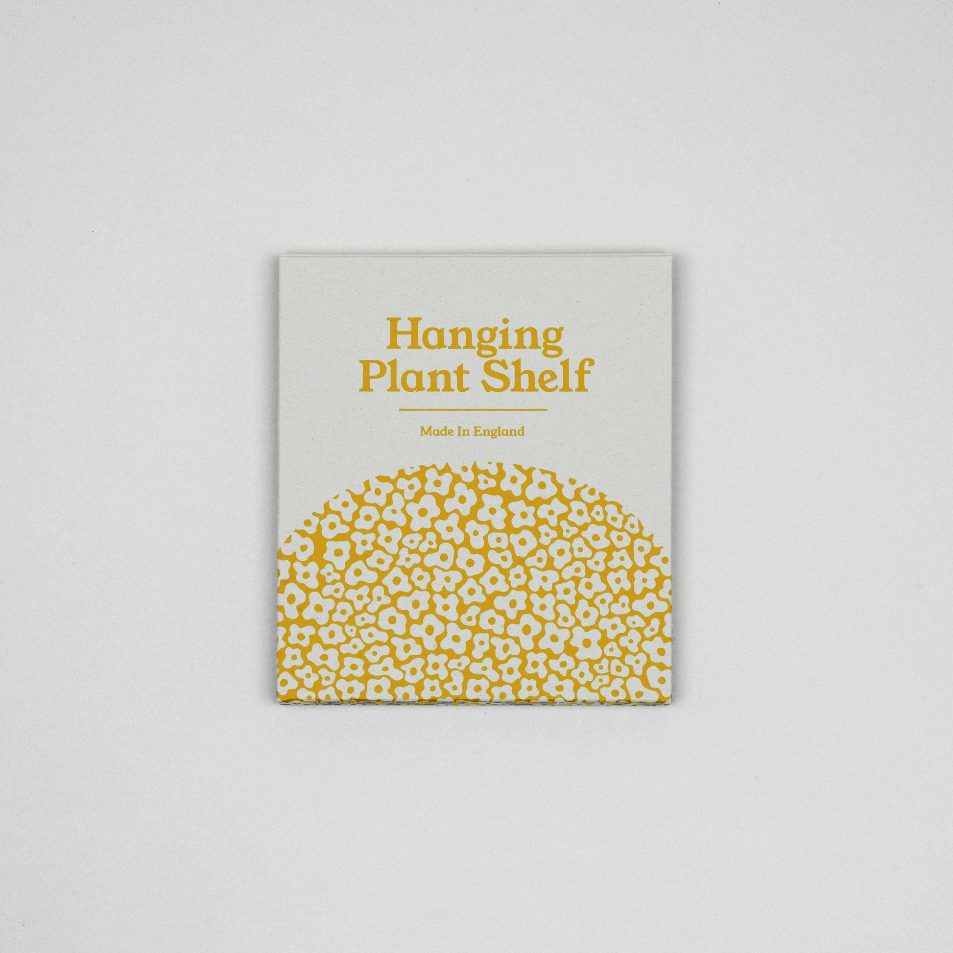Product packaging for a hanging plant shelf with yellow text and pattern on a gray background