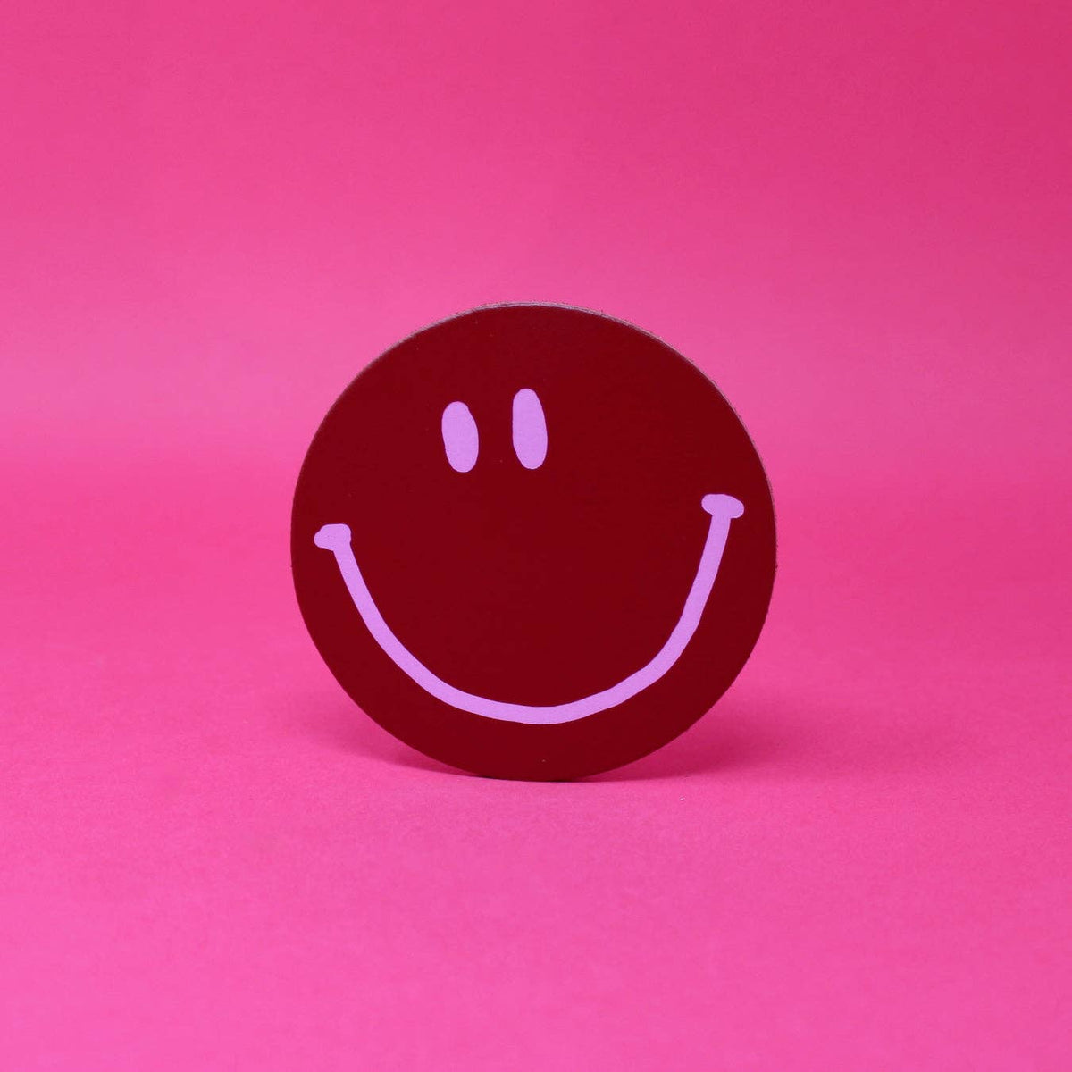 Smiley face icon on a pink background