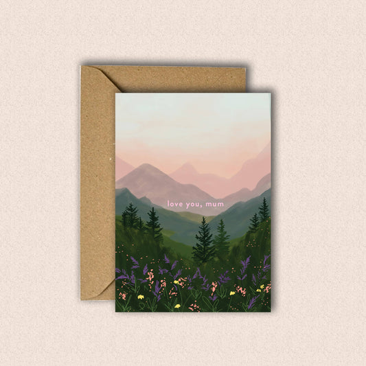 Greeting card with mountain and forest design and 'love you, mum' text on a beige background