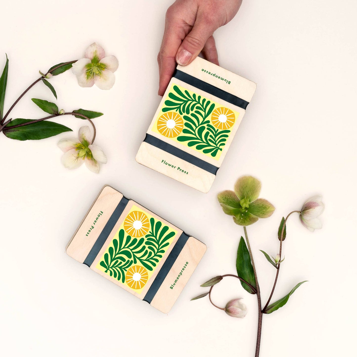 Two notebooks with floral designs on a white background with flowers and leaves.