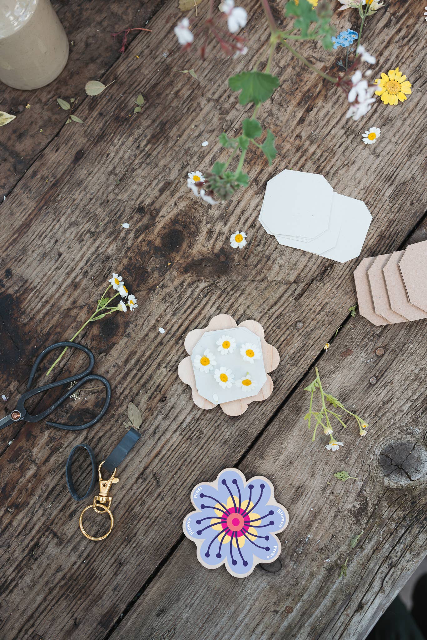 Floral stickers on a wooden surface with scissors and flowers.
