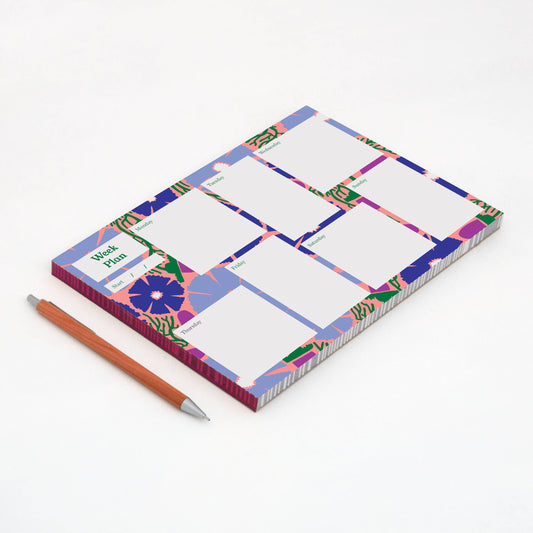 Notebook with colorful design and a pen on a white background