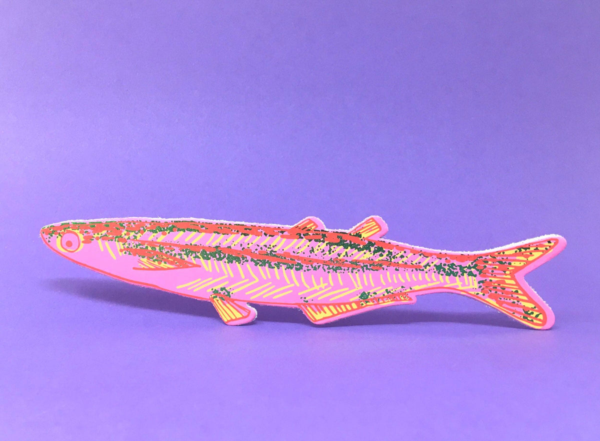 Decorative fish-shaped object with floral patterns on a purple background