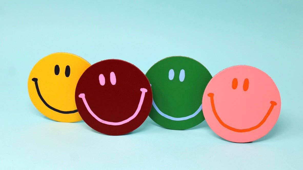 Four colorful smiley faces on a light blue background