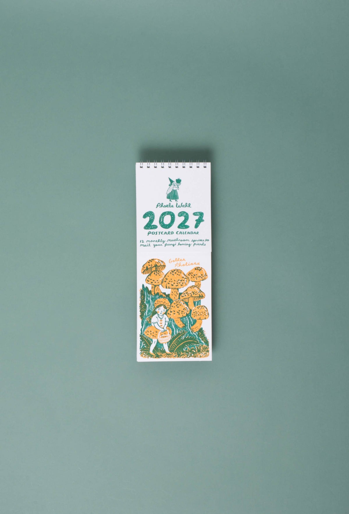 A vertical desk calendar for 'Mula Karva 2027' featuring a white cover with green text and an illustration of a child among orange and yellow mushrooms, set against a solid sage green background.