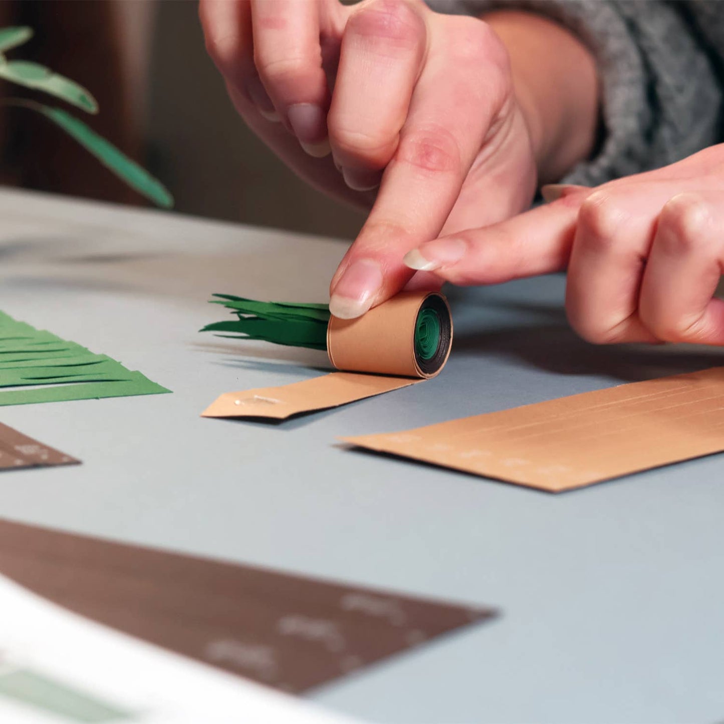 Person crafting with paper strips on a table