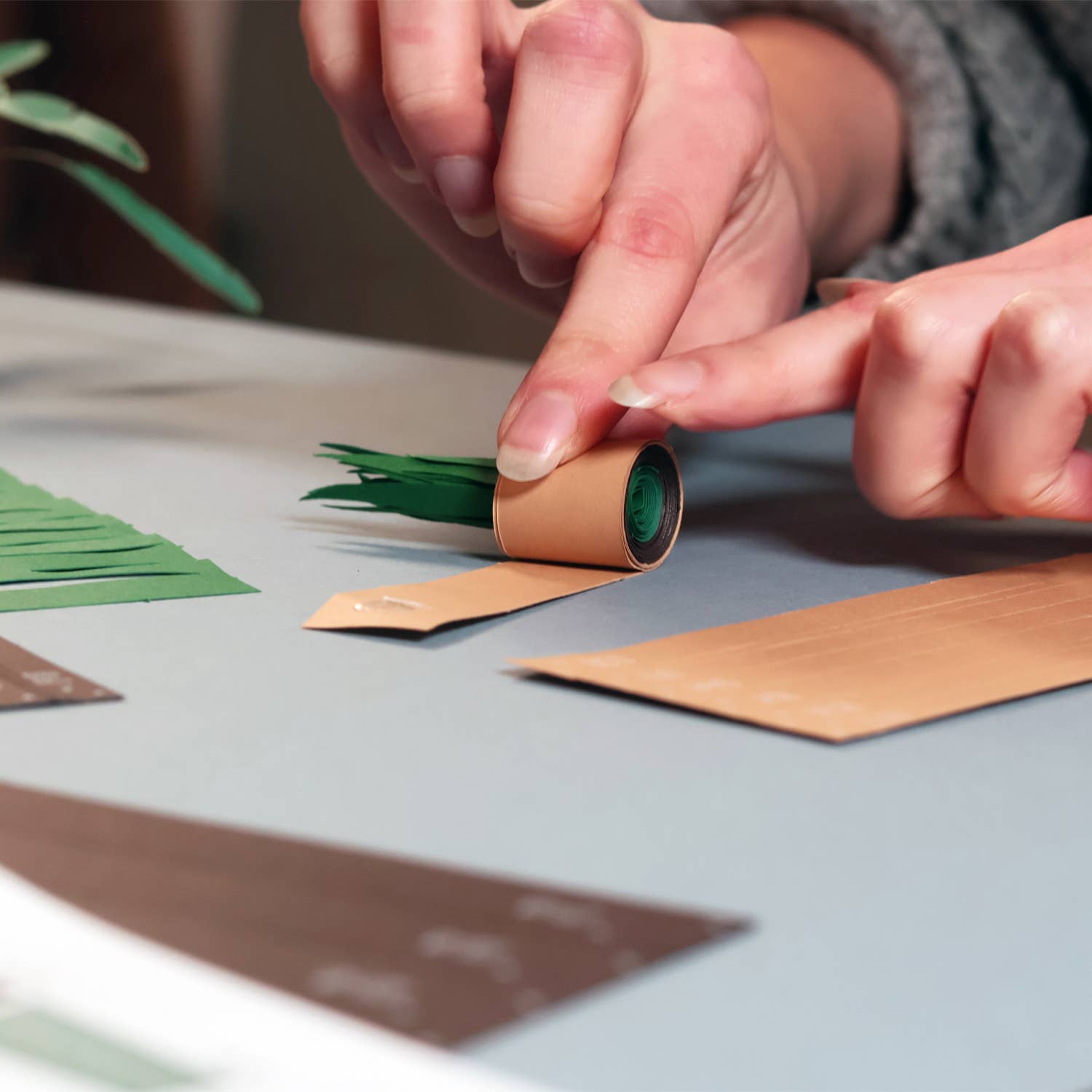 Person crafting with paper strips on a table