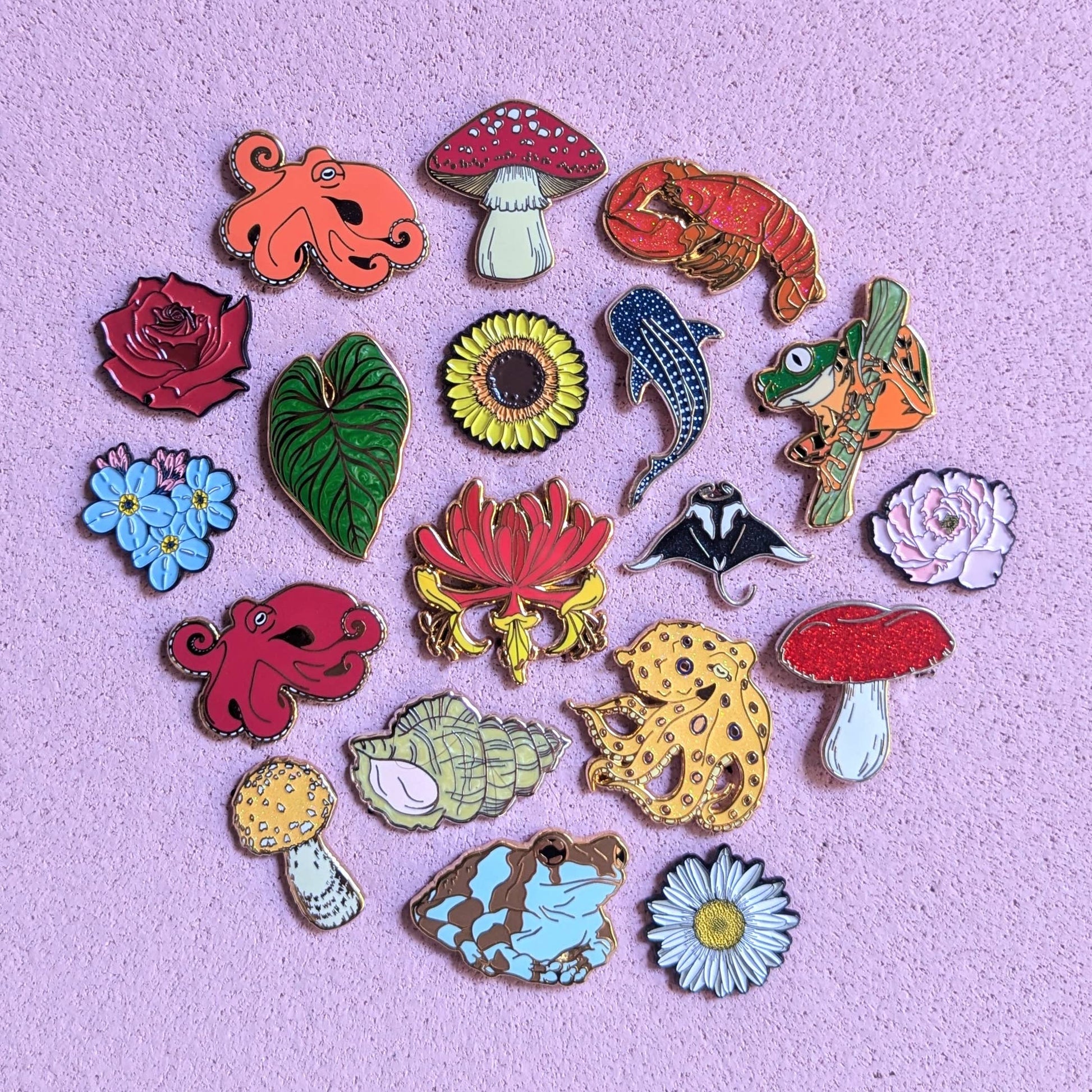 Collection of colorful enamel pins on a purple background