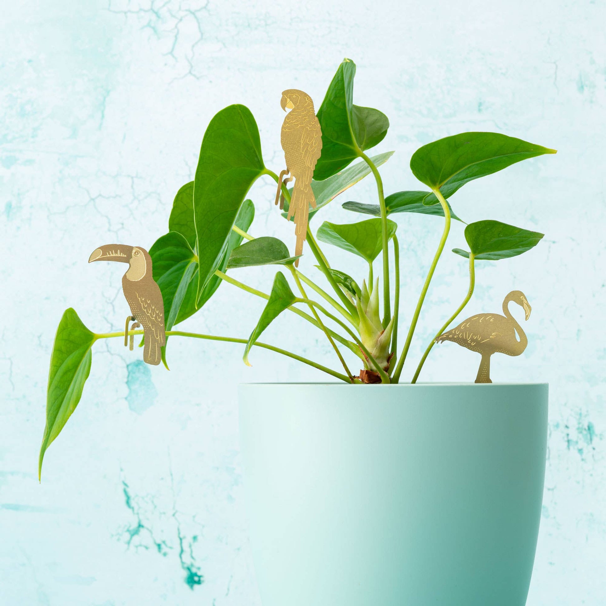 Decorative plant markers shaped like birds in a pot with a light blue background