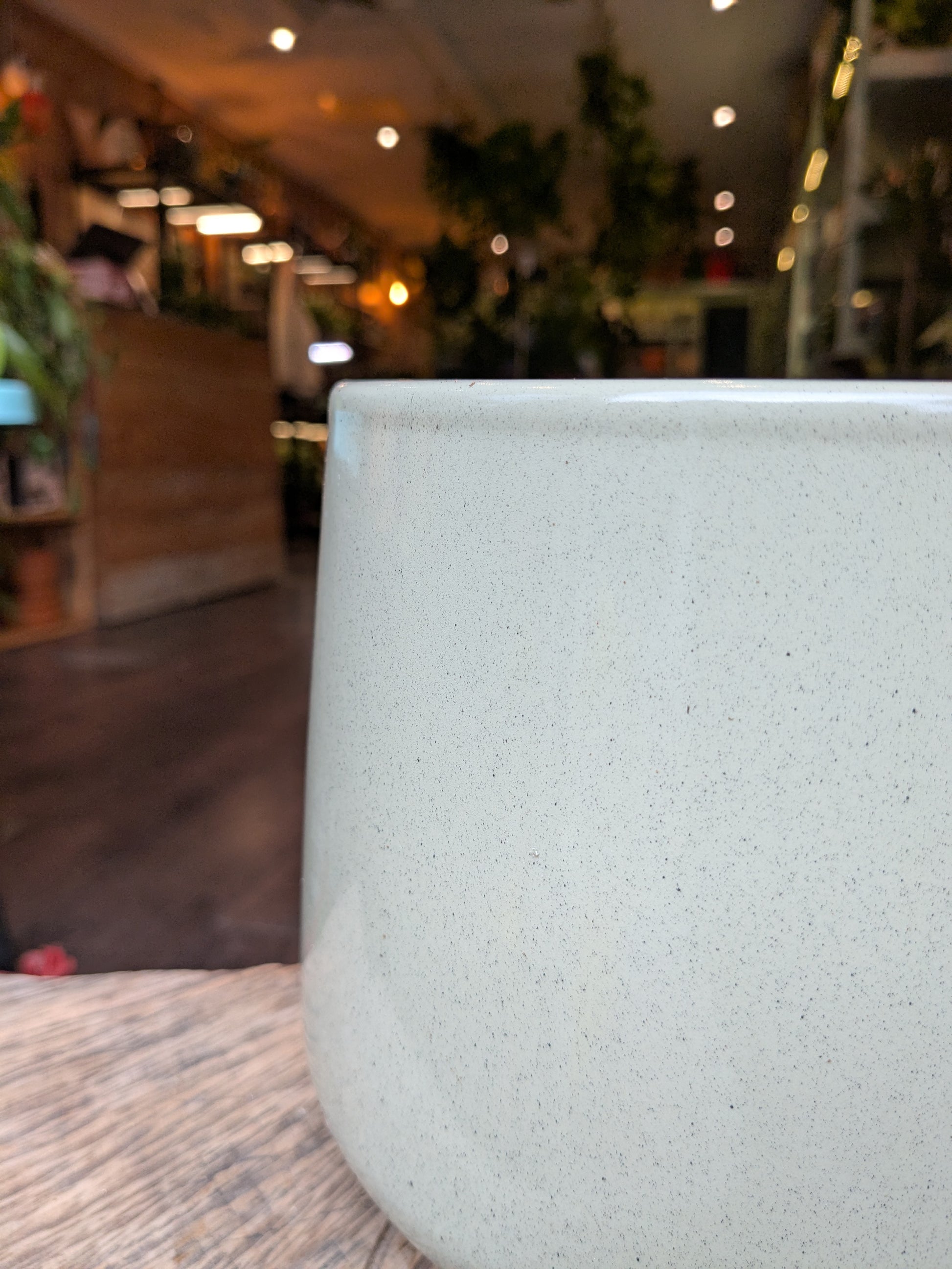 Close-up of a textured white ceramic cup with a blurred indoor background