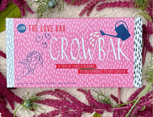 Pink packaging for 'The Love Bar Growbar' with gardening elements and text.