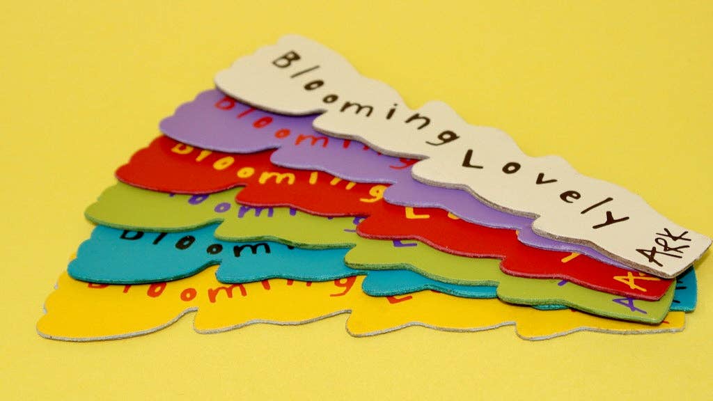 Colorful paper cutouts with 'Blooming Lovely' text on a yellow background