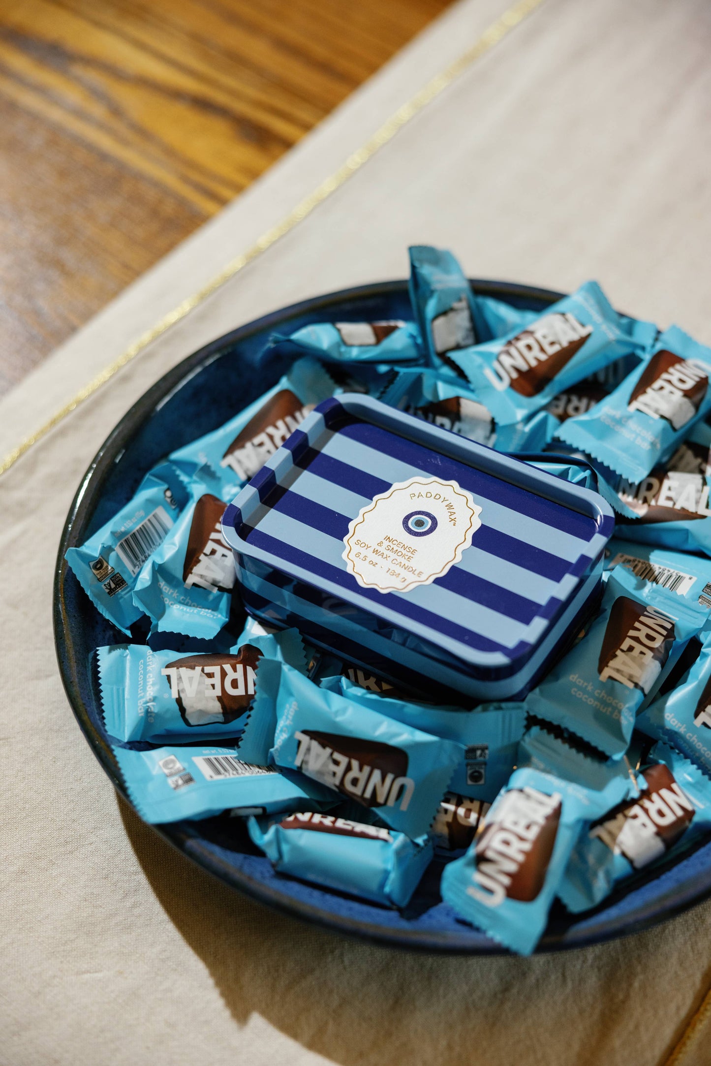 Blue candy bars with a striped box in the center on a wooden surface