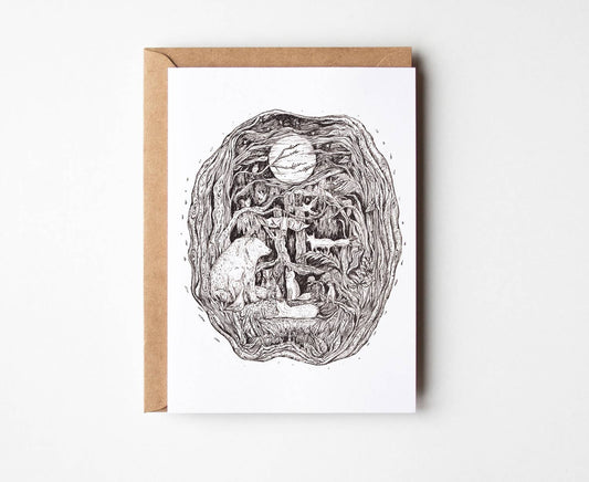 A white greeting card by Helen Drake with a detailed black ink illustration of a surreal forest scene featuring a cat, a tree, and a basketball, shown with a brown kraft envelope on a light gray background.