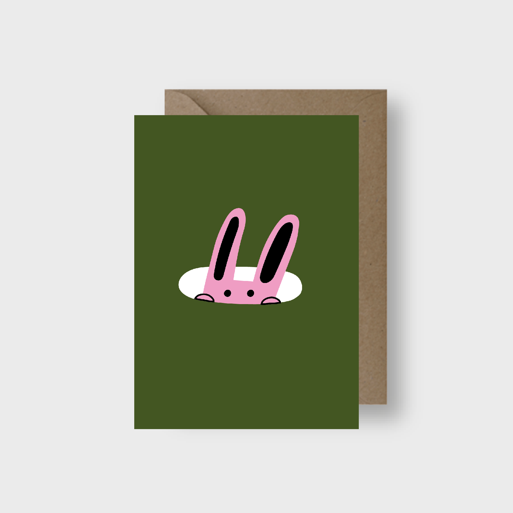 Green greeting card with pink rabbit illustration and brown envelope on a white background