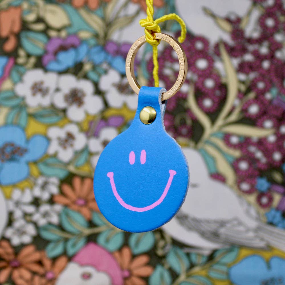 Blue smiley face keychain on a floral background