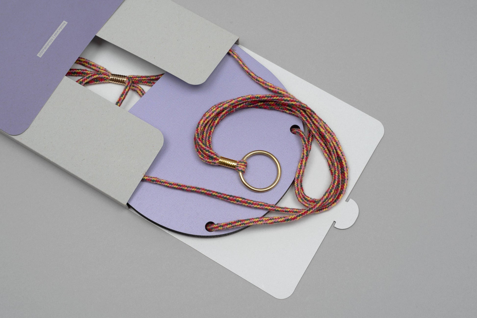 Lanyard with a key ring on a purple card with gray envelope