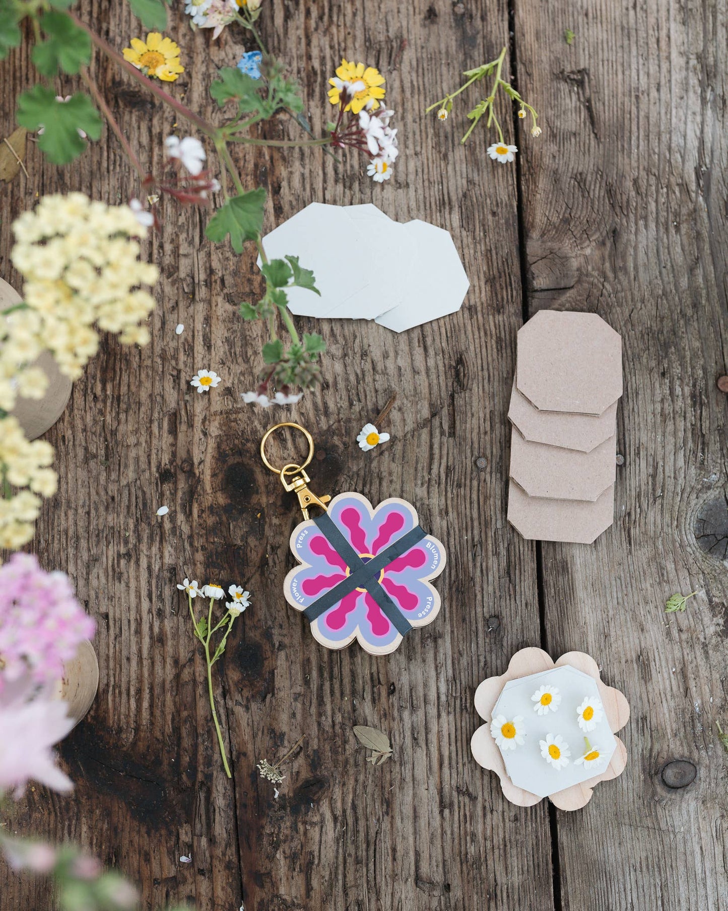 Decorative keychain and stickers on a wooden surface with flowers