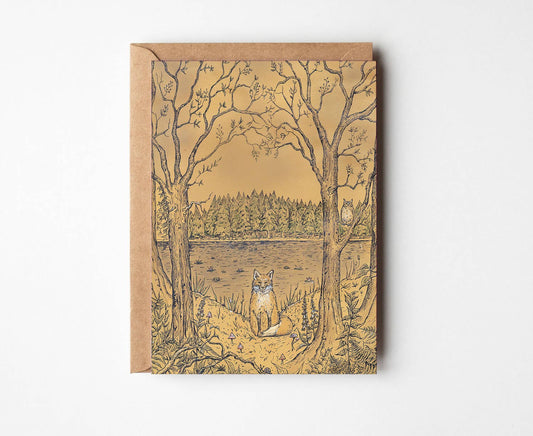 A square kraft paper art print or card featuring an illustrated forest scene with bare trees, a pond, and a fox, shown against a plain white background.