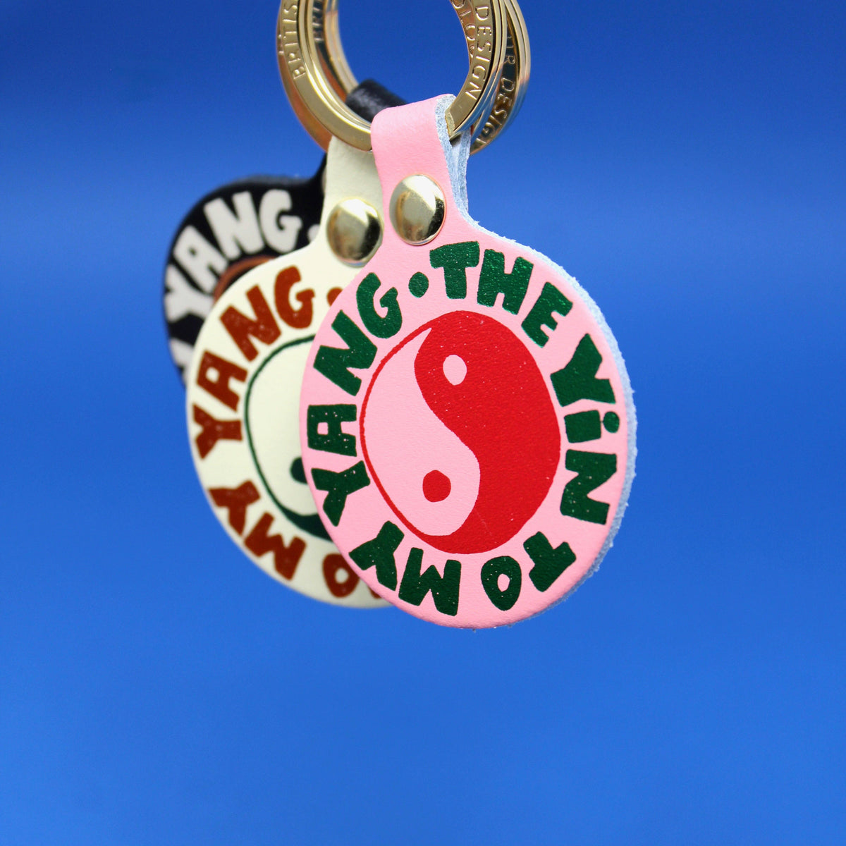 Keychain with round tag featuring a yin yang symbol and text on a blue background